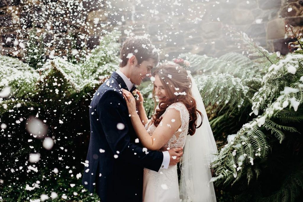 Snow falling on a Winter Wedding couple